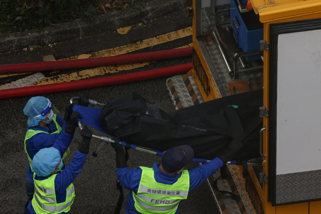 Workers transport body recovered from the rubble at Wang Fuk Court housing estate after a major fire that killed at least 44 people and left almost 300 missing, in Tai Po, Hong Kong, China, November 27, 2025. REUTERS/Tyrone Siu/Tyrone Siu