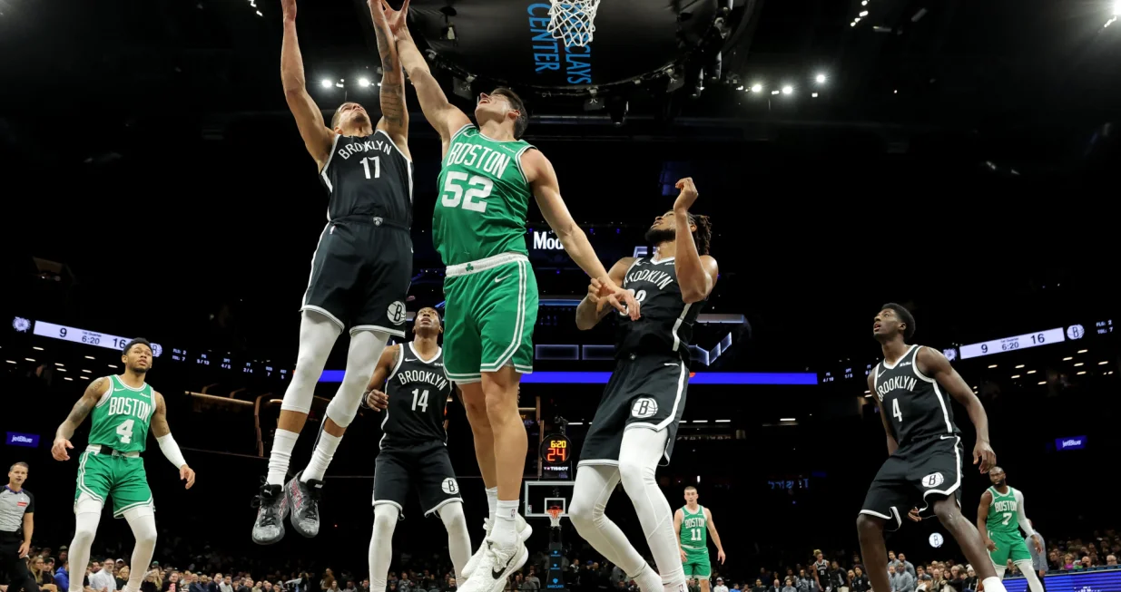Nov 18, 2025; Brooklyn, New York, USA; Boston Celtics center Luka Garza (52) fights for a rebound against Brooklyn Nets forward Michael Porter Jr. (17) and guard Terance Mann (14) and center Nic Claxton (33) during the first quarter at Barclays Center. Mandatory Credit: Brad Penner-Imagn Images/Foto: Brad Penner