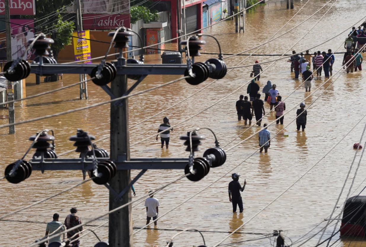 People walk along a flooded street, following heavy rainfall in Wellampitiya, Sri Lanka, November 30, 2025. REUTERS/Thilina Kaluthotage/Thilina Kaluthotage