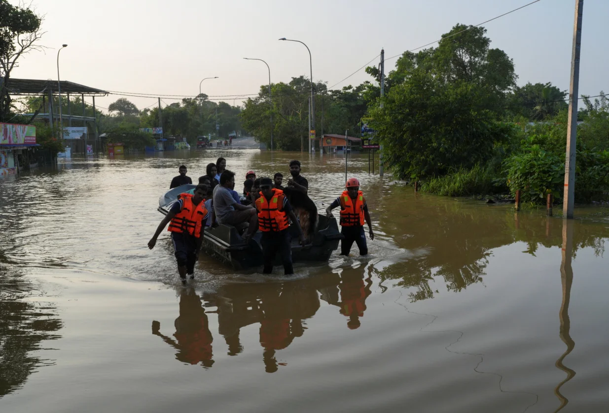 People ride on a boat belonging to Sri Lanka's army at a flooded area following Cyclone Ditwah in Kelaniya, Sri Lanka, November 30, 2025. REUTERS/Thilina Kaluthotage/Thilina Kaluthotage