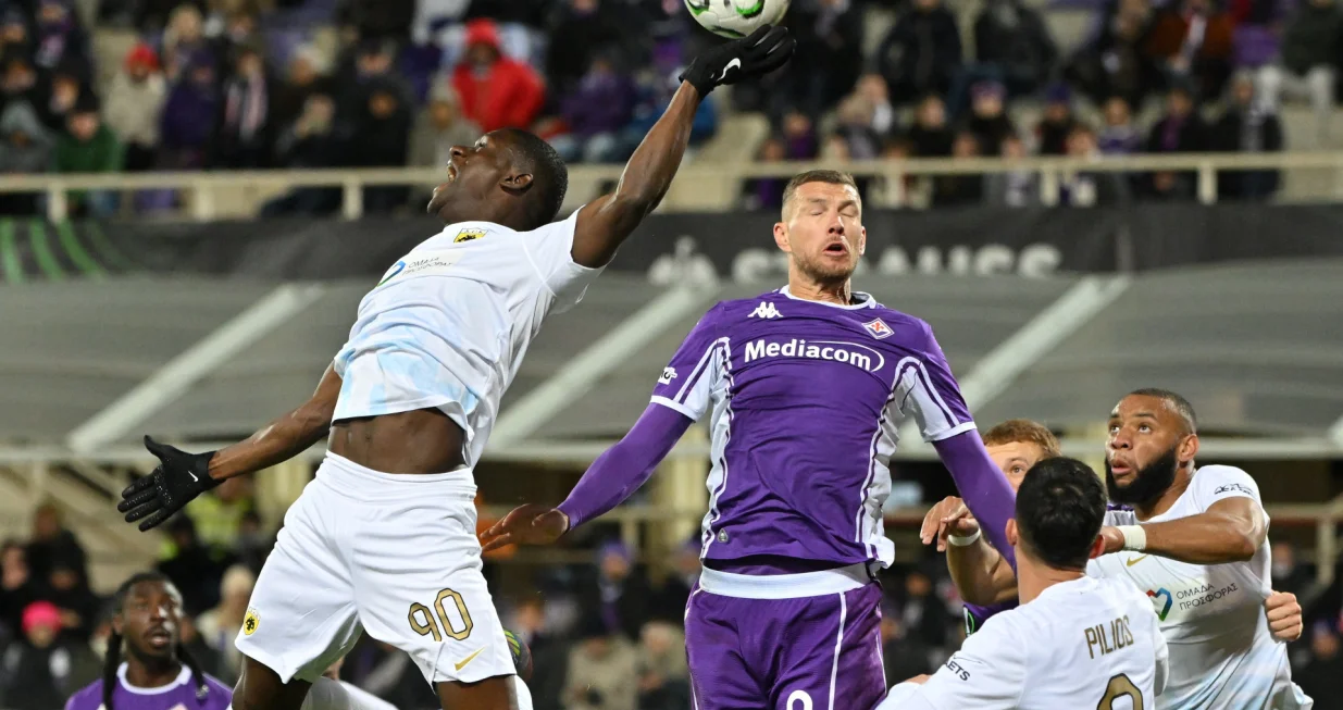 Soccer Football - UEFA Conference League - Fiorentina v AEK Athens - Stadio Artemio Franchi, Florence, Italy - November 27, 2025 AEK Athens' Zini in action with Fiorentina's Edin Dzeko REUTERS/Alberto Lingria/Foto: Alberto Lingria