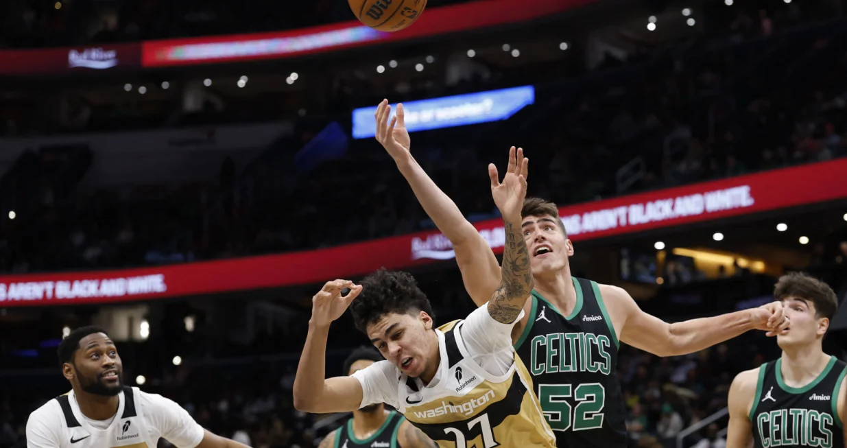 Dec 4, 2025; Washington, District of Columbia, USA; Boston Celtics center Luka Garza (52) reaches over Washington Wizards guard Will Riley (27) for a rebound in the second half at Capital One Arena. Mandatory Credit: Geoff Burke-Imagn Images/Foto: Geoff Burke