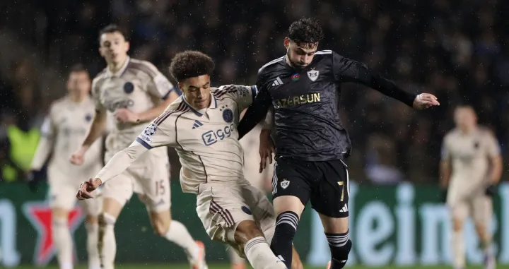 Soccer Football - UEFA Champions League - Qarabag v Ajax Amsterdam - Tofiq Bahramov Republican Stadium, Baku, Azerbaijan - December 10, 2025 Ajax Amsterdam's Aaron Bouwman in action with Qarabag's Nariman Akhundzade REUTERS/Aziz Karimov/Foto: Aziz Karimov