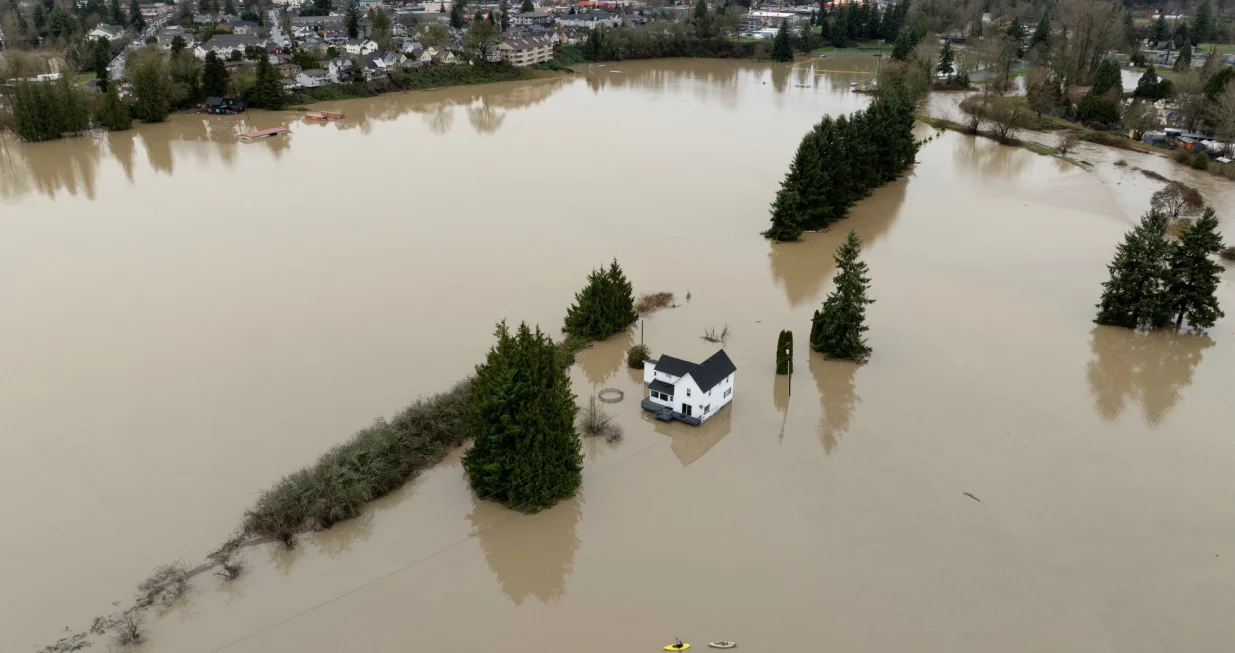 A drone view shows a kayaker near a home in an area flooded by the Snohomish River, as an atmospheric river brings rain and flooding to the Pacific Northwest, in Snohomish, Washington, U.S., December 11, 2025. REUTERS/David Ryder/David Ryder