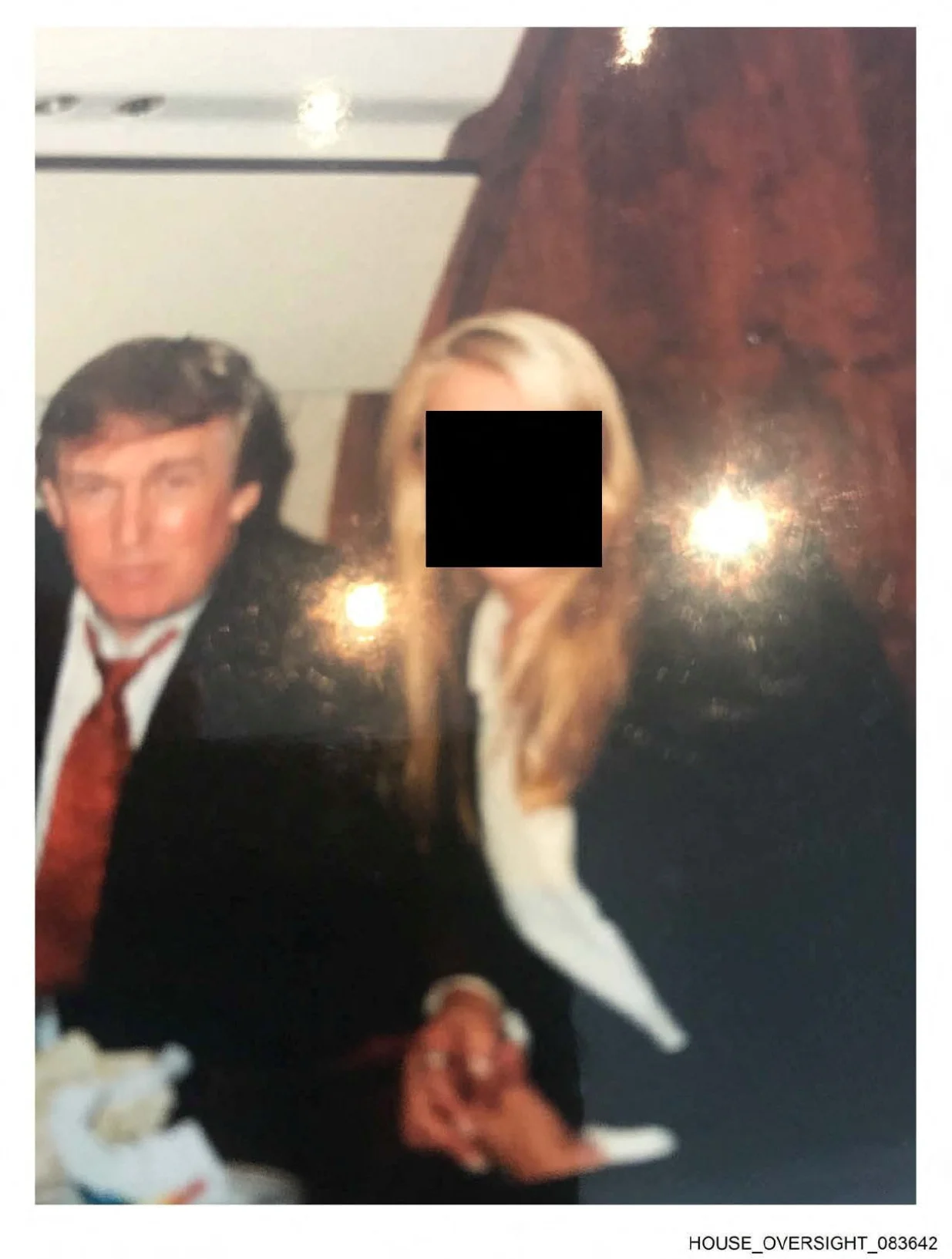 U.S. President Donald Trump is seen with an unidentified woman in this handout image from the estate of the late financier and convicted sex offender Jeffrey Epstein, released by Democrats on the House Oversight Committee in Washington, D.C., U.S., on December 12, 2025. House Oversight Committee Democrats/Handout via REUTERS THIS IMAGE HAS BEEN SUPPLIED BY A THIRD PARTY. REDACTED AREA FROM SOURCE./House Oversight Committee Democr