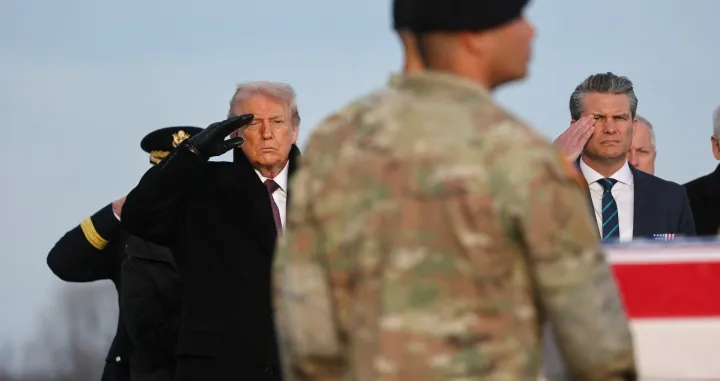 U.S. President Donald Trump and Secretary of Defense Pete Hegseth salute, as members of the military carry a transfer case, during a dignified transfer of the remains of two Iowa National Guard members killed in Syria, Sgt. Edgar Torres Tovar and Sgt. William Howard, and Ayad Mansoor Sakat, of Macomb, Michigan, who was working as an interpreter in Syria, at Dover Air Force Base in Dover, Delaware, U.S., December. 17, 2025. REUTERS/Jonathan Ernst/Jonathan Ernst