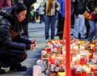 A woman places a candle outside the "Le Constellation" bar, after a fire and explosion during a New Year's Eve party where people died, and others were injured, in the upscale ski resort of Crans-Montana in southwestern Switzerland, January 2, 2026. REUTERS/Stephanie Lecocq  TPX IMAGES OF THE DAY/Stephanie Lecocq