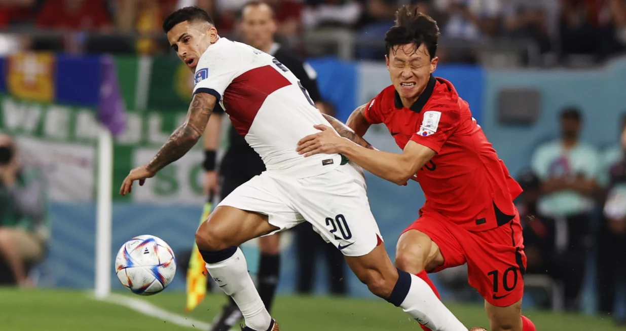 epa10344355 Joao Cancelo of Portugal (L) in action against Lee Jae-sung of South Korea during the FIFA World Cup 2022 group H soccer match between South Korea and Portugal at Education City Stadium in Doha, Qatar, 02 December 2022. EPA/Rungroj Yongrit/Foto: Rungroj Yongrit