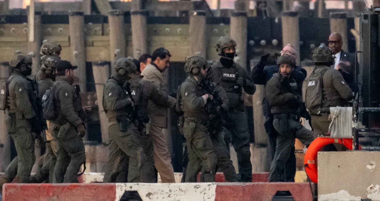 Captured Venezuelan President Nicolas Maduro is escorted, as he heads towards the Daniel Patrick Moynihan United States Courthouse in Manhattan for an initial appearance to face U.S. federal charges including narco-terrorism, conspiracy, drug trafficking, money laundering and others, at Downtown Manhattan Heliport, in New York City, U.S., January 5, 2026. REUTERS/Adam Gray/Adam Gray