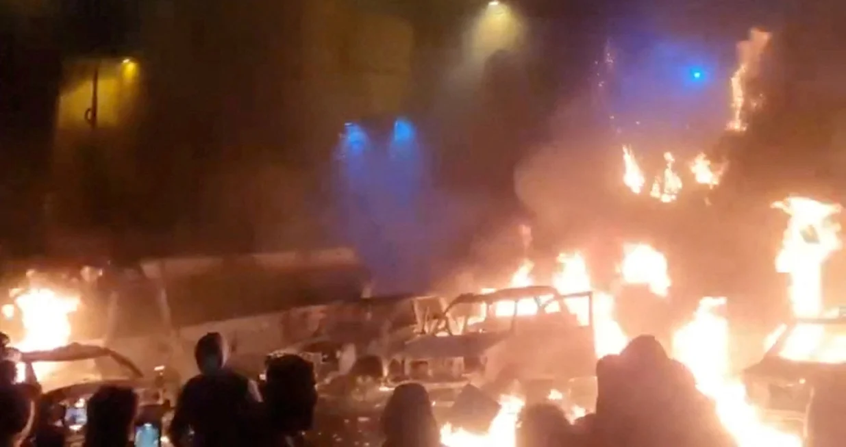 Protesters gather as vehicles burn, amid evolving anti-government unrest, in Tehran, Iran, in this screen grab obtained from a social media video released on January 9, 2026. Social Media/via REUTERS THIS IMAGE HAS BEEN SUPPLIED BY A THIRD PARTY. NO RESALES. NO ARCHIVES. REFILE - QUALITY REPEAT VERIFICATION: - Buildings, business signage and traffic light matched file and satellite imagery - Date not verified - Witnesses told Reuters protesters gathered in the streets on Thursday (January 8)/Social Media