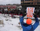 A demonstrator holds a placard during an "ICE Out of Minnesota" rally and march organized by MIRAC (Minnesota Immigrant Rights Action Committee), in Minneapolis, Minnesota, U.S., January 10, 2026. REUTERS/Tim Evans  TPX IMAGES OF THE DAY/Tim Evans