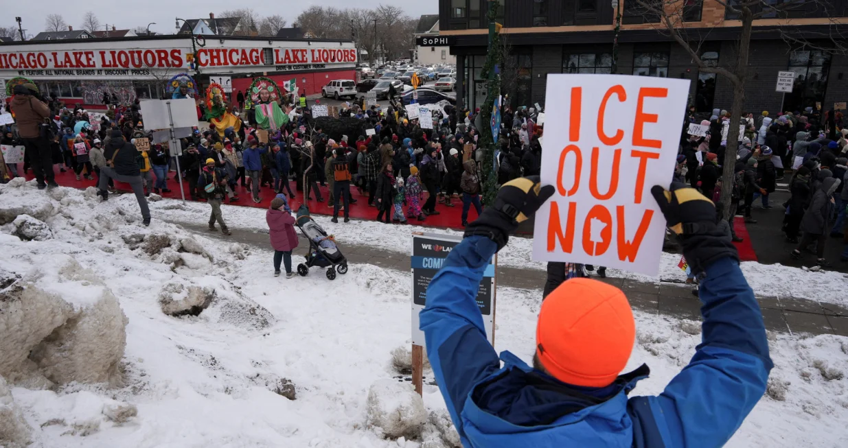 A demonstrator holds a placard during an "ICE Out of Minnesota" rally and march organized by MIRAC (Minnesota Immigrant Rights Action Committee), in Minneapolis, Minnesota, U.S., January 10, 2026. REUTERS/Tim Evans  TPX IMAGES OF THE DAY/Tim Evans