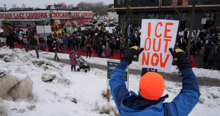 A demonstrator holds a placard during an "ICE Out of Minnesota" rally and march organized by MIRAC (Minnesota Immigrant Rights Action Committee), in Minneapolis, Minnesota, U.S., January 10, 2026. REUTERS/Tim Evans  TPX IMAGES OF THE DAY/Tim Evans