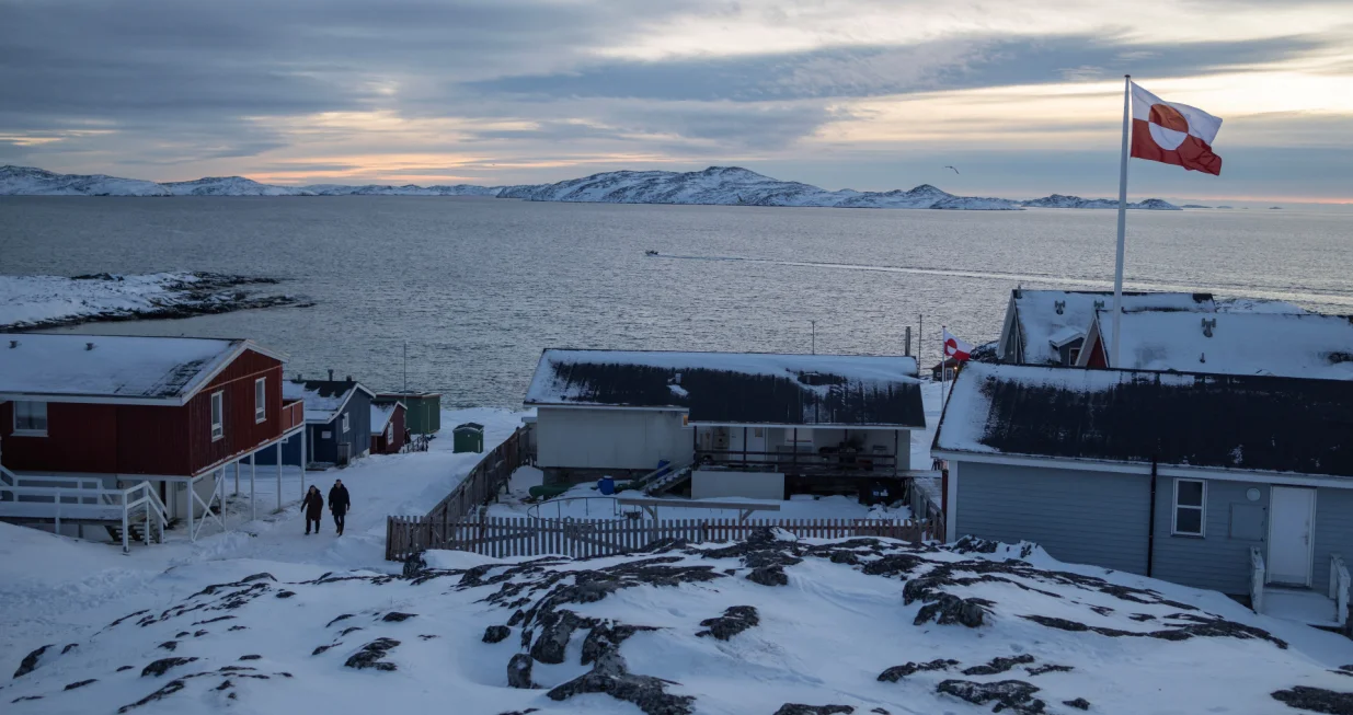A Greenland flag flies as people walk on the day of a meeting between top U.S. officials and the foreign ministers of Denmark and Greenland, in Nuuk, Greenland, January 14, 2026. REUTERS/Marko Djurica/Marko Djurica
