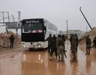 A bus driver speaks with members of the Syrian army, after an agreement failed between Syrian Democratic Forces (SDF) with the Syrian government, where SDF members were supposed to evacuate to northeastern Syria after days of fighting with the Syrian army, in Aleppo, Syria, January 9, 2026. REUTERS/Khalil Ashawi/Khalil Ashawi