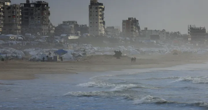 Palestinians walk on a beach during a weather disturbance in Gaza City, January 9, 2026. REUTERS/Dawoud Abu Alkas/Dawoud Abu Alkas