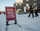 People walk past a sign placed on a street in Nuuk, Greenland, Tuesday, January 20, 2026. Ritzau Scanpix/ Mads Claus Rasmussen via REUTERS ATTENTION EDITORS - THIS IMAGE WAS PROVIDED BY A THIRD PARTY. DENMARK OUT. NO COMMERCIAL OR EDITORIAL SALES IN DENMARK./Mads Claus Rasmussen