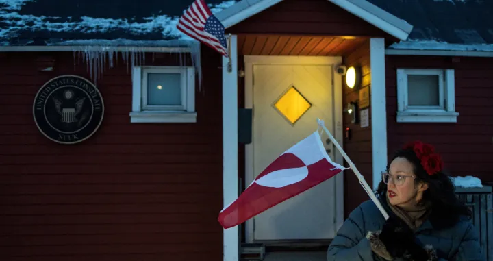 A person displays a Greenlandic flag, as people protest in front of the U.S. consulate in Nuuk, Greenland, January 22, 2026. REUTERS/Marko Djurica  TPX IMAGES OF THE DAY/Marko Djurica