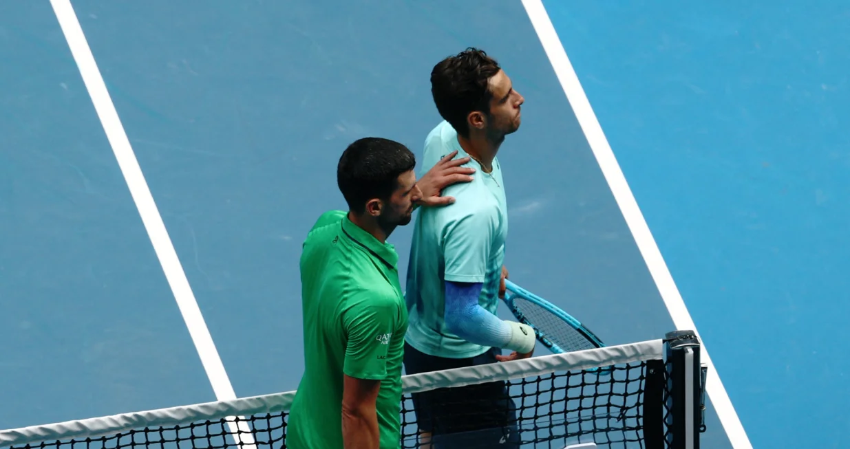 Tennis - Australian Open - Melbourne Park, Melbourne, Australia - January 28, 2026 Italy's Lorenzo Musetti with Serbia's Novak Djokovic after retiring from his quarter final match REUTERS/Tingshu Wang/Foto: Tingshu Wang