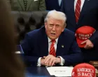 U.S. President Donald Trump sits behind a bill he signed to end the partial government shutdown, at the White House in Washington, D.C., U.S., February 3, 2026. REUTERS/Evelyn Hockstein/Evelyn Hockstein