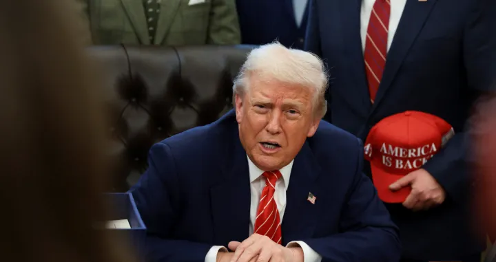 U.S. President Donald Trump sits behind a bill he signed to end the partial government shutdown, at the White House in Washington, D.C., U.S., February 3, 2026. REUTERS/Evelyn Hockstein/Evelyn Hockstein