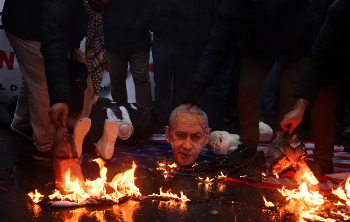 Demonstrators set fire to cutouts depicting Israeli Prime Minister Benjamin Netanyahu and U.S. President Donald Trump during a rally in solidarity with Iran's government in Tehran, near the Iranian Consulate in Istanbul, Turkey, January 18, 2026. REUTERS/Dilara Senkaya/Dilara Senkaya