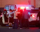 People embrace near a police officer outside the Dennis M Lynch Arena, an indoor ice skating rink, after a shooting in Pawtucket, Rhode Island, U.S., February 16, 2026. REUTERS/CJ Gunther/Cj Gunther