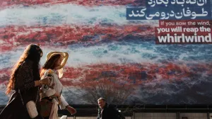 Iranian women walk past an anti-U.S. billboard in Tehran, Iran, February 19, 2026. Majid Asgaripour/WANA (West Asia News Agency) via REUTERS ATTENTION EDITORS - THIS PICTURE WAS PROVIDED BY A THIRD PARTY/Majid Asgaripour