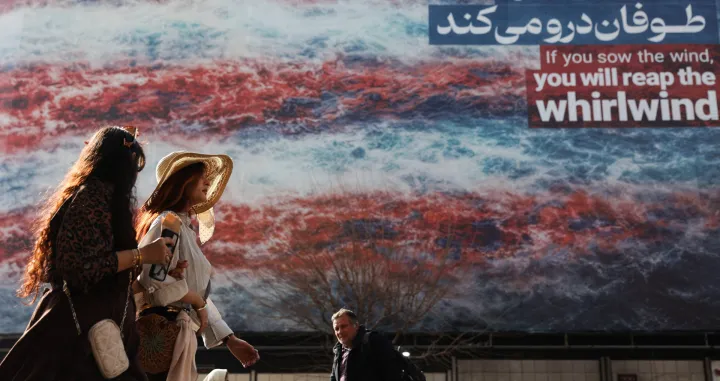 Iranian women walk past an anti-U.S. billboard in Tehran, Iran, February 19, 2026. Majid Asgaripour/WANA (West Asia News Agency) via REUTERS ATTENTION EDITORS - THIS PICTURE WAS PROVIDED BY A THIRD PARTY/Majid Asgaripour