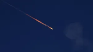 FILE PHOTO: A fragment falls through the sky after Israel's Iron Dome intercepted a missile launched from Iran towards Israel, amid the Iran-Israel conflict, as seen from Ashkelon, Israel June 20, 2025. REUTERS/Amir Cohen/File Photo/Amir Cohen