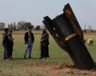People stand next to a missile after it fell near Qamishli International Airport, amid the U.S.-Israeli conflict with Iran, in Qamishli, Syria, March 4, 2026. REUTERS/Orhan Qereman REFILE &ndash; REMOVING ATTRIBUTION OF THE MISSILE/Orhan Qereman