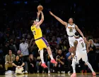 Mar 14, 2026; Los Angeles, California, USA; Los Angeles Lakers guard Luka Doncic (77) shoots a game winning shot while under pressure from Denver Nuggets forward Spencer Jones (21) during overtime at Crypto.com Arena. Mandatory Credit: William Liang-Imagn Images/Foto: William Liang