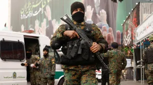 Members of the police stand guard on a street, with a large billboard featuring Iran's late Supreme Leader Ayatollah Ali Khamenei in the background, amid the U.S.-Israeli conflict with Iran, in Tehran, Iran, March 12, 2026. REUTERS/Alaa Al-Marjani/Alaa Al-marjani