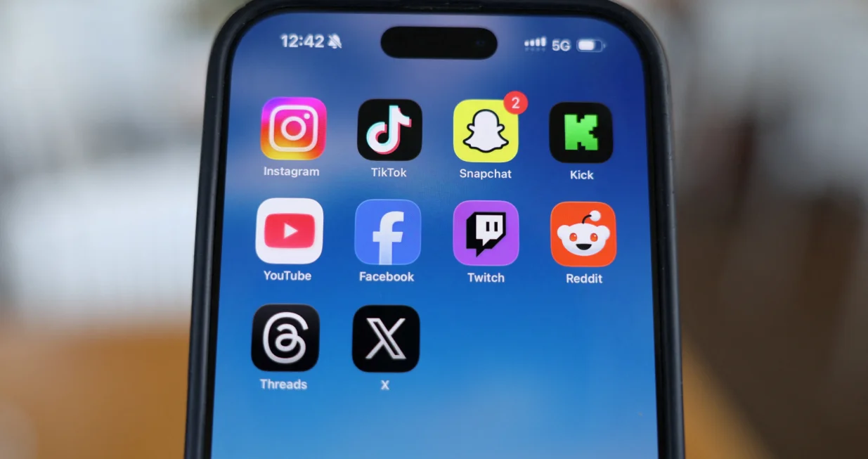 Instagram, TikTok, Snapchat, Kick, YouTube, Facebook, Twitch, Reddit, Threads and X applications are displayed on a mobile phone ahead of new law banning social media for users under 16 in Australia, in this picture illustration taken on December 9, 2025. REUTERS/Hollie Adams/Illustration/Hollie Adams